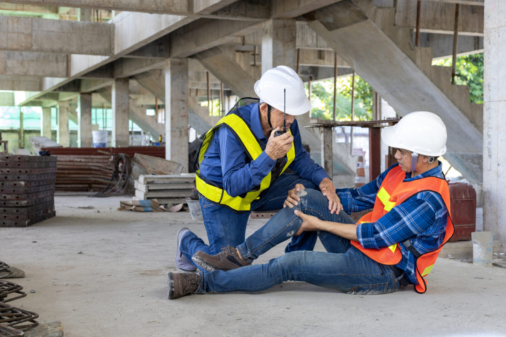 Asian factory workers having accident while working in manufacturing site while his colleague is helping for safety workplace and emergency